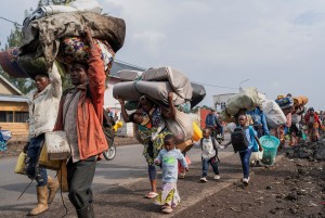 Internally displaced civilians from the camps in Munigi and Kibati, carry their belongings as they flee to Goma